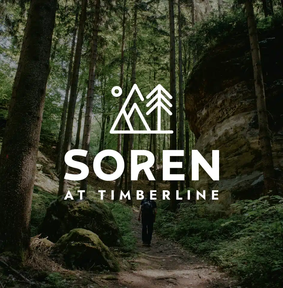Hiker walking through lush forest trail with logo.