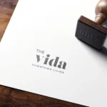 Wooden stamp marks paper with 'Vida' logo.