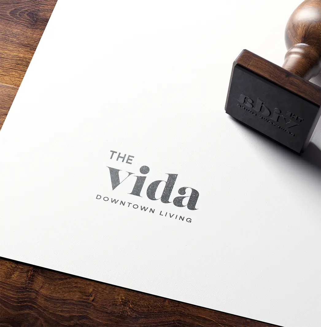 Wooden stamp marks paper with 'Vida' logo.