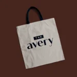Reusable beige tote bag with 'The Avery' print.