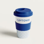 Reusable blue and white coffee cup with 'The Uptown' text.