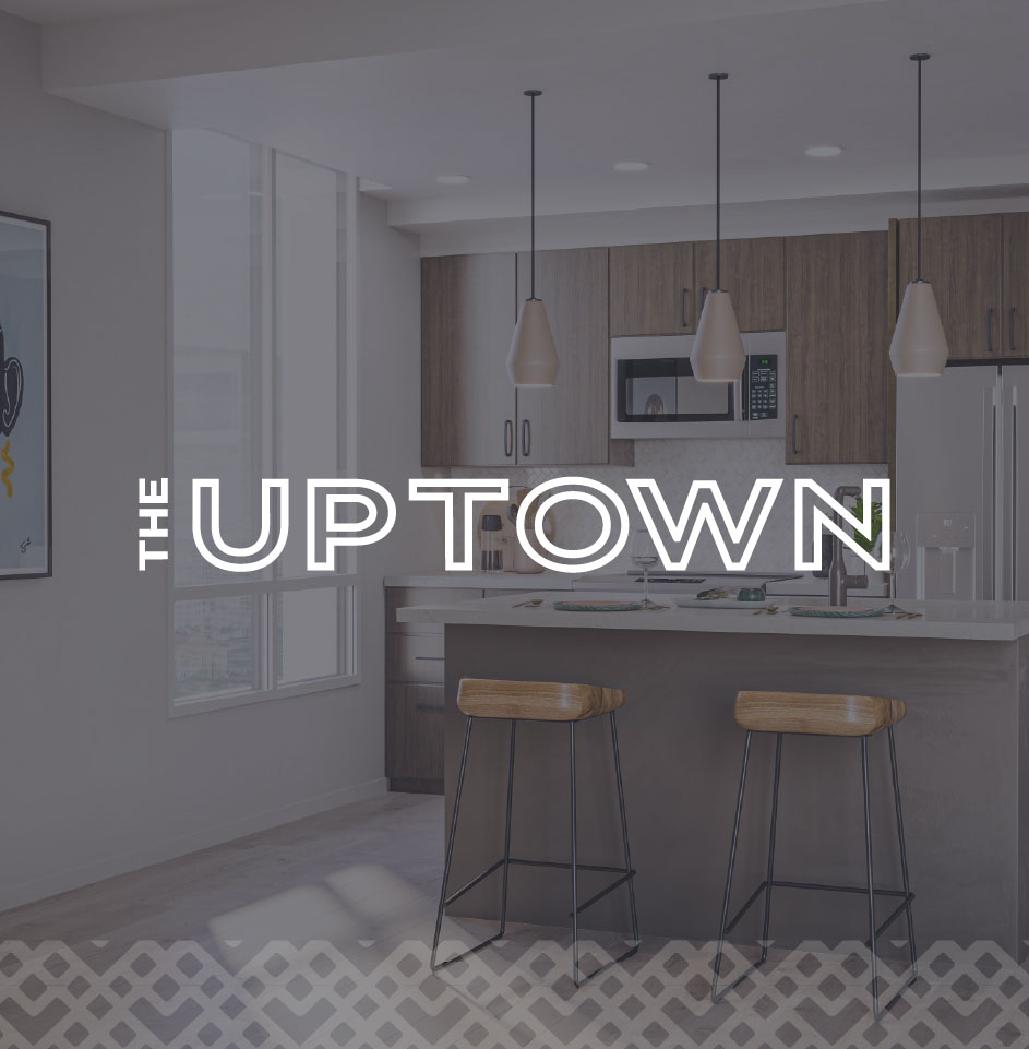 Modern kitchen with bar stools and lighting.