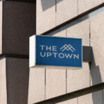 The Uptown building sign in blue and white.